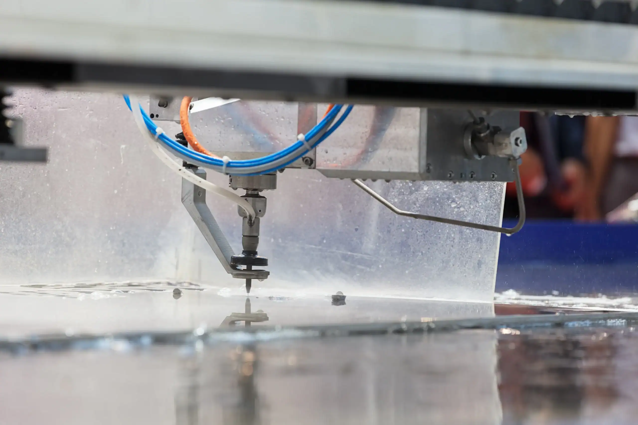 Close-up of a water jet cutting machine precisely slicing metal at Precision Waterjet Cutting Long Island.